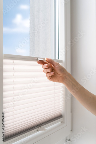 Slika na platnu woman open cordless blind shutter on window
