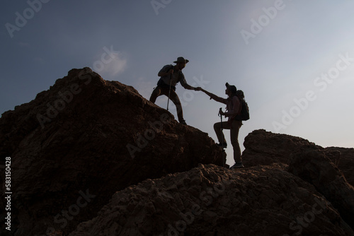 hiker on top of mountain. silhouette of a person standing on a rock. silhouette of a person on a rock. silhouette of a person