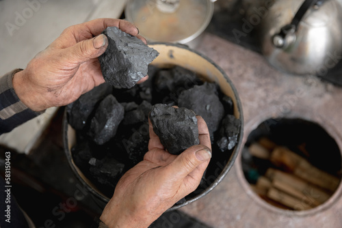 Coal in hand of old man holds. Concept industry mining.