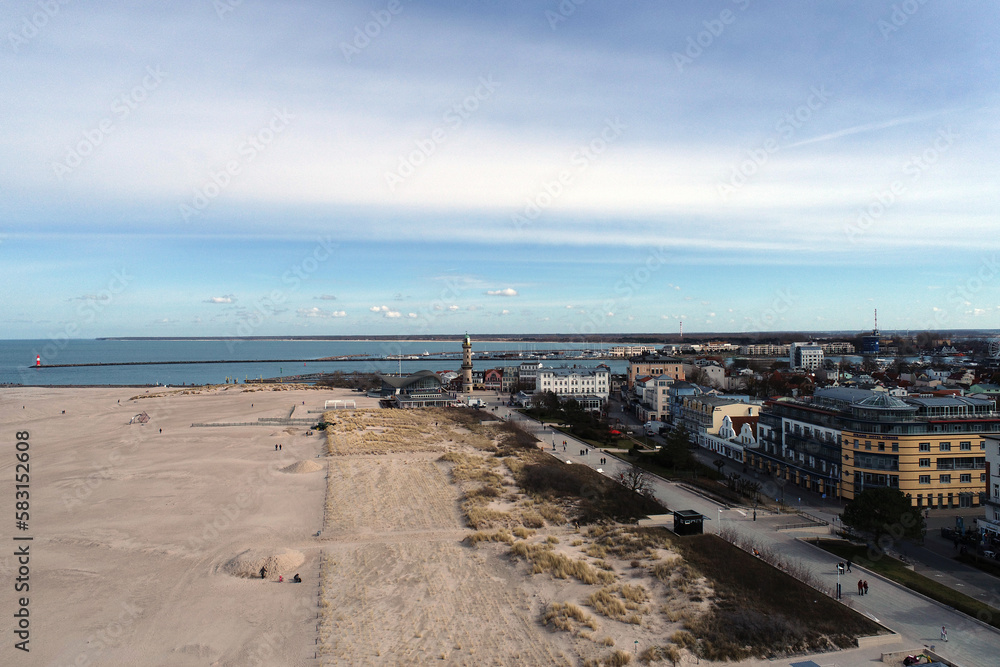 The beach in Rostock-Warnemünde with a lighthouse in the background (Germany)