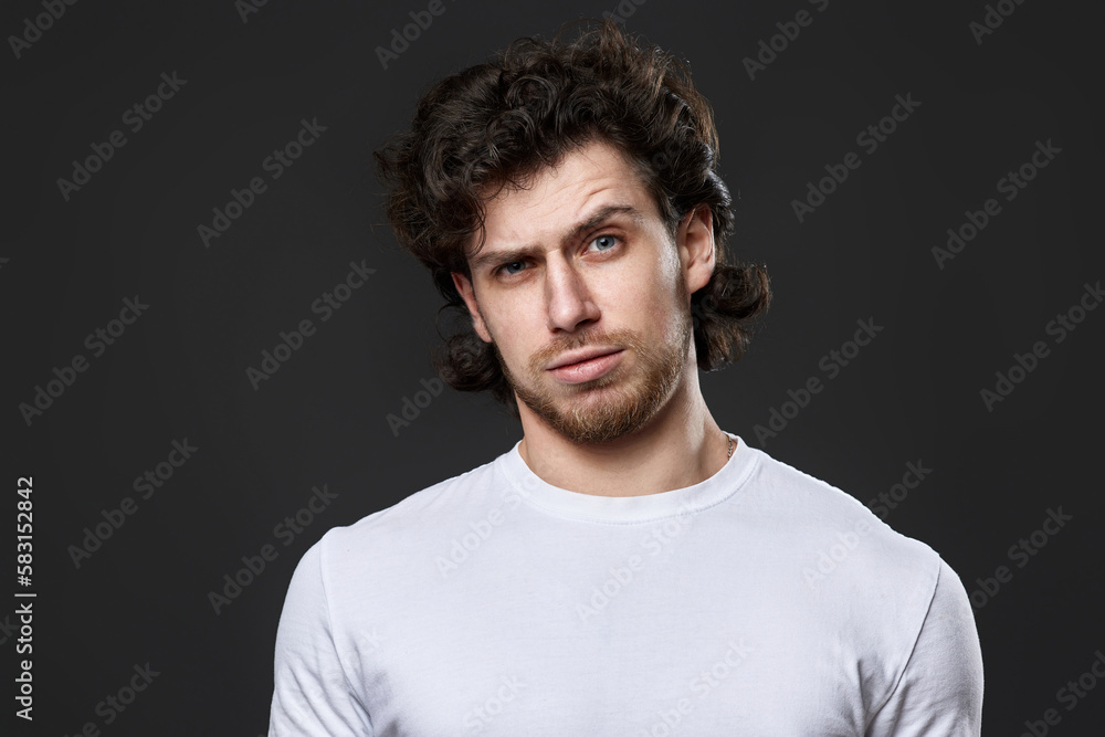 Fototapeta premium skeptic and nervous man in white t-shirt on dark gray background