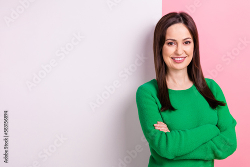 Photo of positive pretty woman wear green sweater arms crossed poster emtpy space isolated pink color background © deagreez