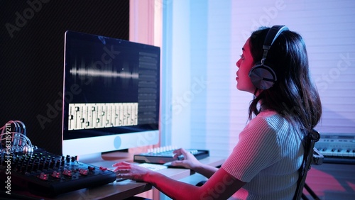 Foto Beautiful stylish young woman sound producer sitting at the controls in the reco