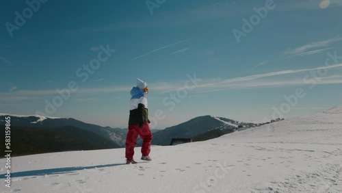 Woman achieving her goal by reaching the top of the mountain. Female stuggling walking on hard snow in the mountains. photo