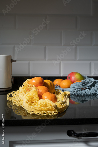 cloth bags with fresh fruit, yellow and blue bags, in kitchen
 photo