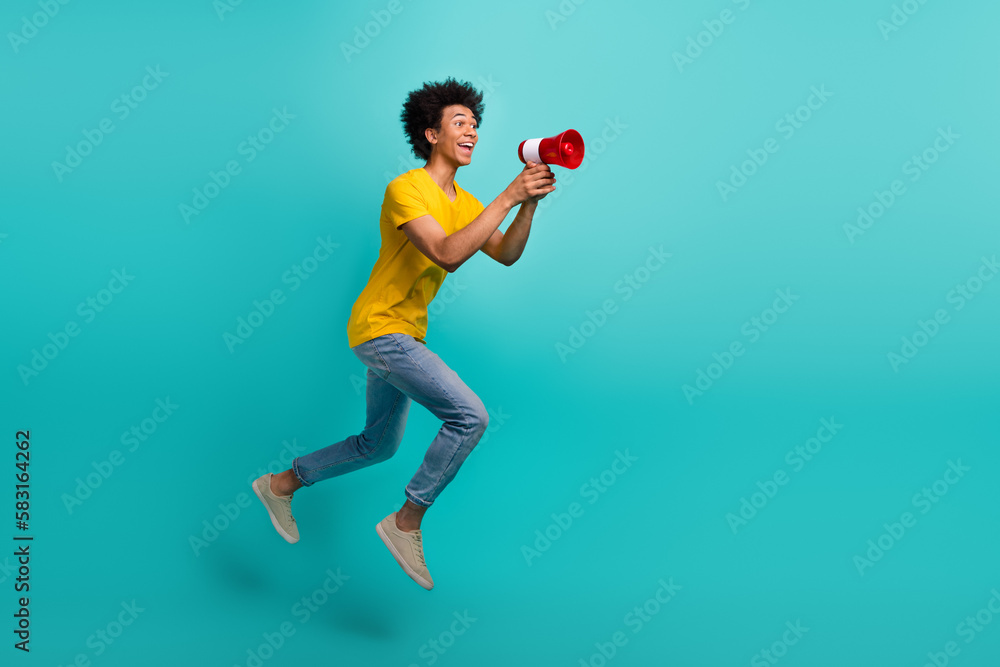 Full body profile photo of excited man jump rush empty space hold toa loudspeaker isolated on teal color background Full body profile photo of excited man jump rush empty space hold toa loudspeaker isolated on teal color background
