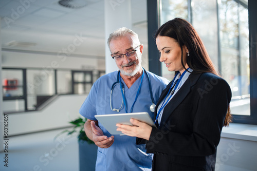 Young pharmaceutic seller explaining something to doctor in hospital.