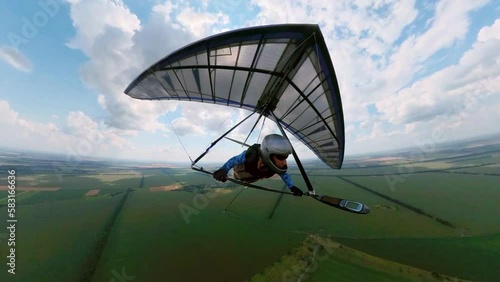 Girl hang glider pilot flies in the air with other pilots