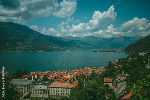 High-angle of lake Garda view on a sunny day with a forested hill and clear sky background © Arne Jørgen Enggrav/Wirestock Creators