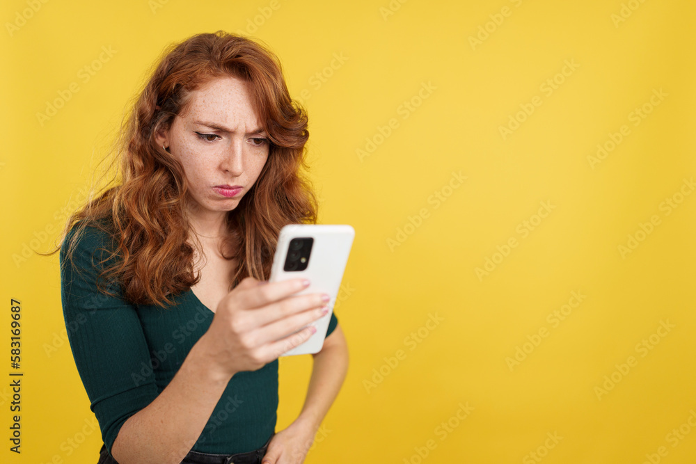 Worried redheaded woman using a mobile phone Worried redheaded woman using a mobile phone