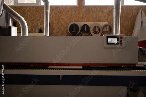 Single sided automatic edge banders on furniture factory, close up. edge banding machine making furniture