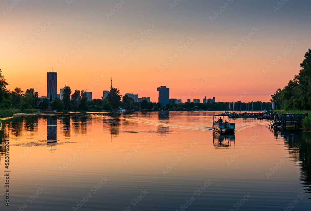 Evening panorama of skyscrapers with river and boats in the foreground