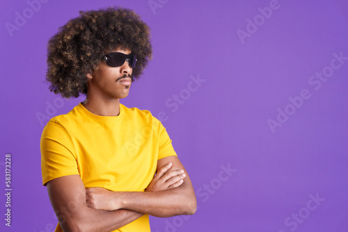 Serious african man wearing sunglasses posing with arms crossed