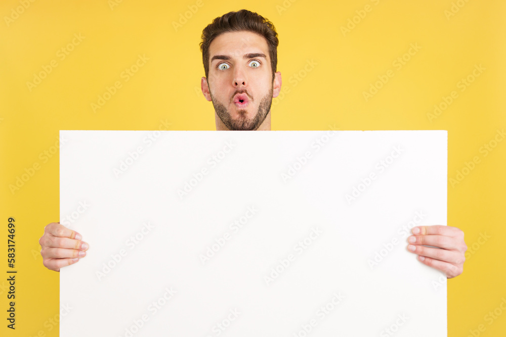 Surprised caucasian man hair holding a blank panel Surprised caucasian man hair holding a blank panel