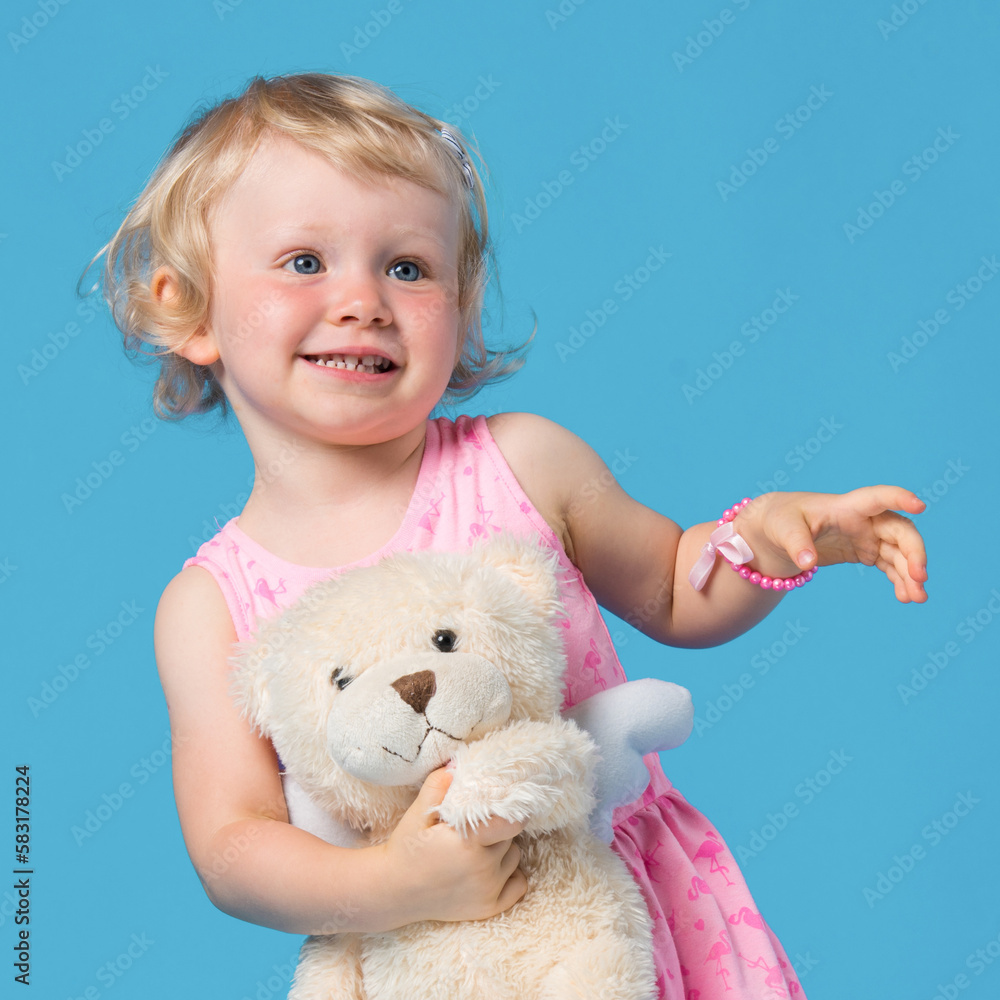 Portrait of beautiful young girl in pink dress against blue background Portrait of beautiful young girl in pink dress against blue background