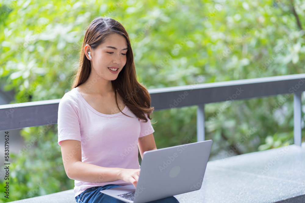Asian female student Studying for exams in the area of the university. Communicate via mobile phone or laptop connected to the Internet. with many sources of knowledge Asian female student Studying for exams in the area of the university. Communicate via mobile phone or laptop connected to the Internet. with many sources of knowledge