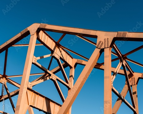 Closeup of girder bridge railway model against sunlit clear sky background