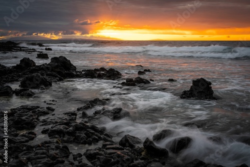 Long exposure shot of a sunrise over the rocky beach in Oahu, Hawaii.