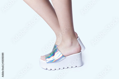 Model in studio photo with white background. Woman's legs. Footwear launch advertisement.