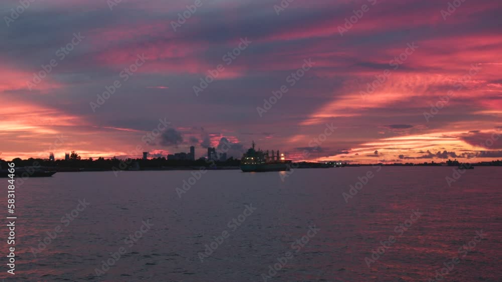 Mississippi River with boats by the coasts under a scenic pink sunset sky Mississippi River with boats by the coasts under a scenic pink sunset sky