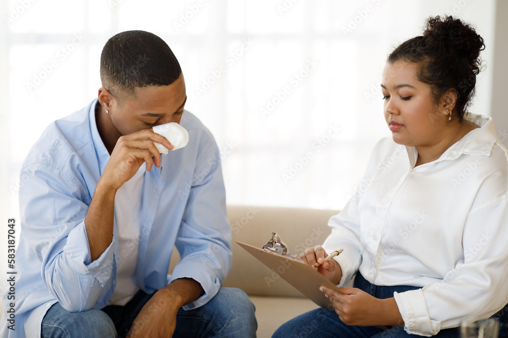 Depressed black guy attending therapy session with psychologist Depressed black guy attending therapy session with psychologist