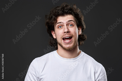 portrait of young smiling man on gray background