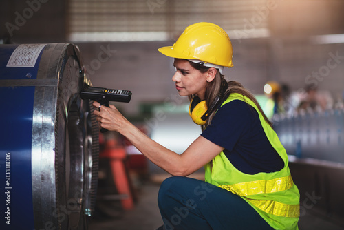 Smiling caucasian woman warehouse worker using barcode scanner for stock checking in factory, Profession female engineer work in metalsheet manufacturing. photo