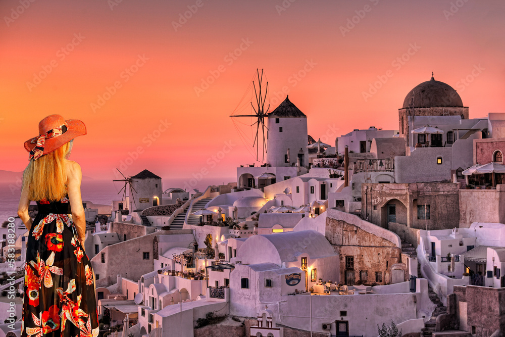 A woman looking the sunset of Oia in Santorini, Greece