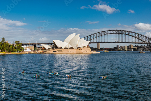 Sydney opera house and harbour bridge. And kayakers in the sea.