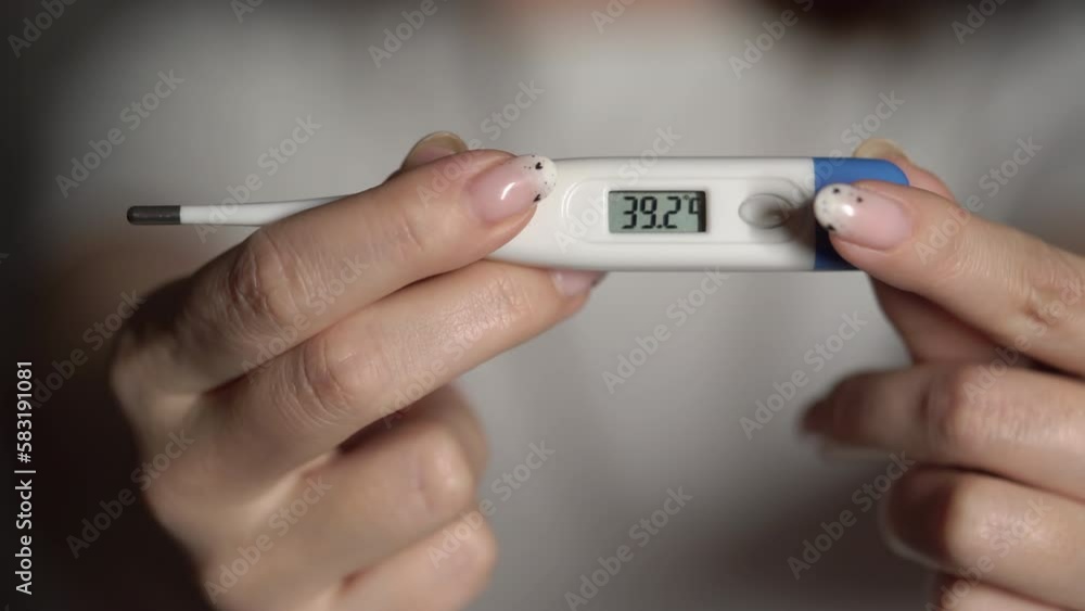 Woman holds thermometer in hands to measure body temperature. 36 degrees Celsius Woman holds thermometer in hands to measure body temperature. 36 degrees Celsius