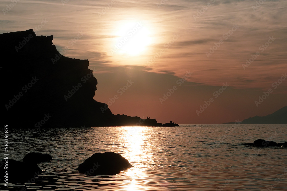 Sunset, waves and volcanic mountain view from Yildizkoy beach on Gokceada Imbros island. Canakkale Turkey