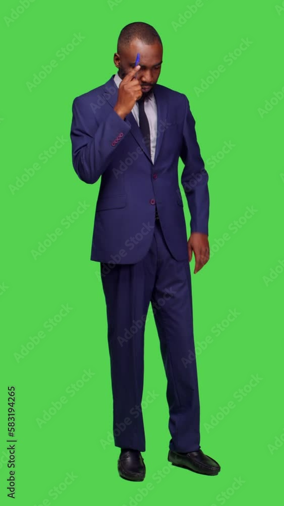 Vertical video: Front view of thoughtful formal person brainstorming new ideas in studio, wearing business office suit and thinking about important startup information. Pensive entrepreneur standing Vertical video: Front view of thoughtful formal person brainstorming new ideas in studio, wearing business office suit and thinking about important startup information. Pensive entrepreneur standing