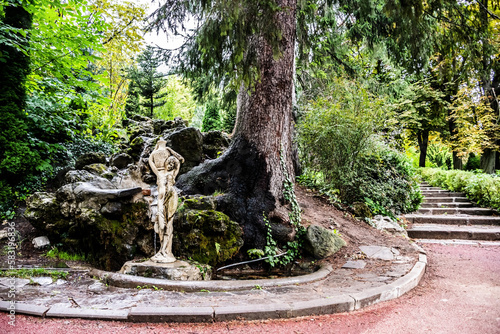 The artesia fountain as a waterfall and the statue of a woman with a jug in Dimitrie Ghica park. Sinaia, Romania. photo