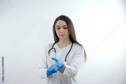 Beautiful Doctor Nurse woman in uniform with stethoscope  wearing rubber gloves act pose oxygen mask in Medical hospital  portrait black hair studio lighting blue background copy space
