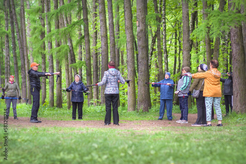 A group of elderly people are recovering in the forest in the open air during a sports workout. Spending time together. Healthy lifestyle, active longevity. Moscow, May 25, 2022