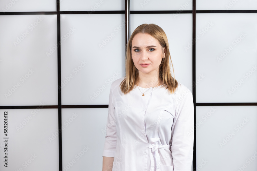 Portrait of a young blonde doctor in a white uniform on a black and white background. Portrait of a young blonde doctor in a white uniform on a black and white background.