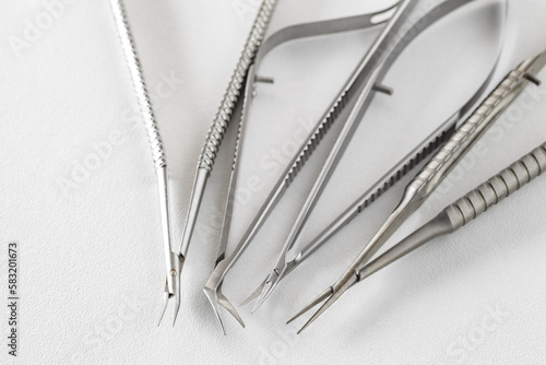 Photos Surgical metal medical instruments ophthalmic scissors, on white, selective focu
