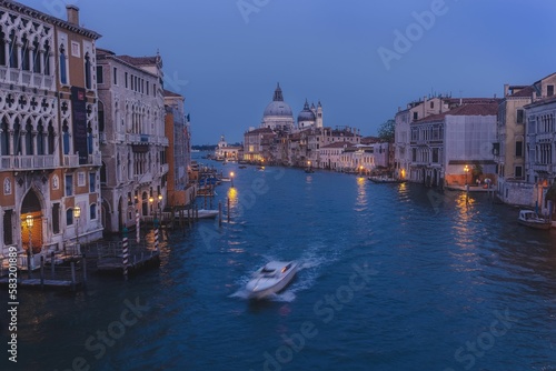 Aerial view of a boat sailing on the canal at night in Venice, Italy