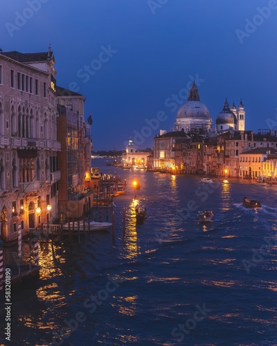Vertical shot of illuminated lights on the shore of the canal in Venice, Italy