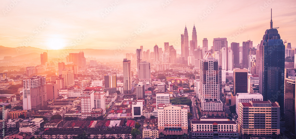Obraz premium Cityscape of Kuala lumpur city skyline with swimming pool on the roof top of hotel at sunrise in Malaysia. Vintange tone