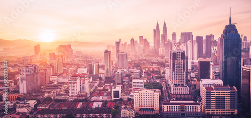 Cityscape of Kuala lumpur city skyline with swimming pool on the roof top of hotel at sunrise in Malaysia. Vintange tone