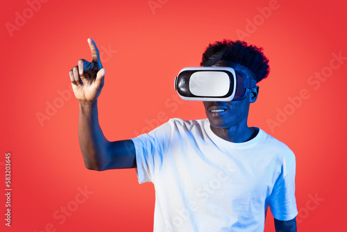 Black man in VR headset touching something invisible, click button