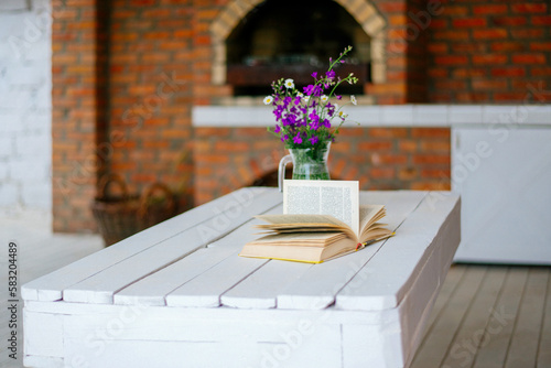 open book and flowers jon the table near fireplace photo