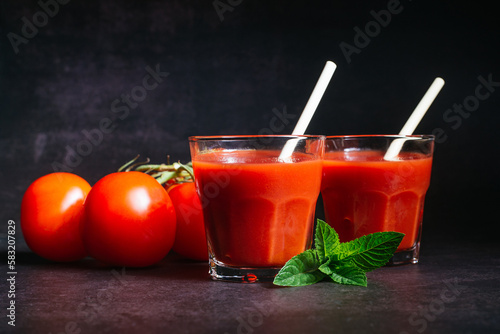 The glasses of tomato juice and a tomatos
