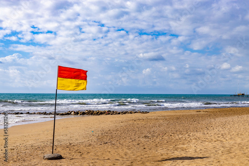 Red and yellow Warning Sign Flag on a beach