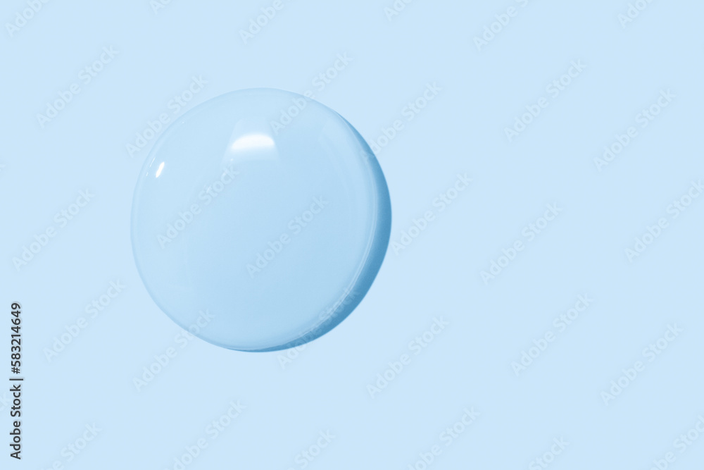 Obraz premium large drops of transparent Gel liquid, water on a blue background, top view, close-up