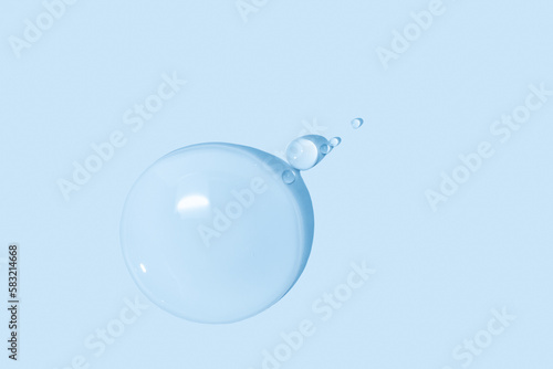large drops of transparent Gel liquid, water on a blue background, top view, close-up