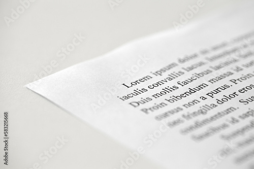 Lorem Ipsum dolor text on printed on paper in black and white, sample of document, side view, selective focus photo