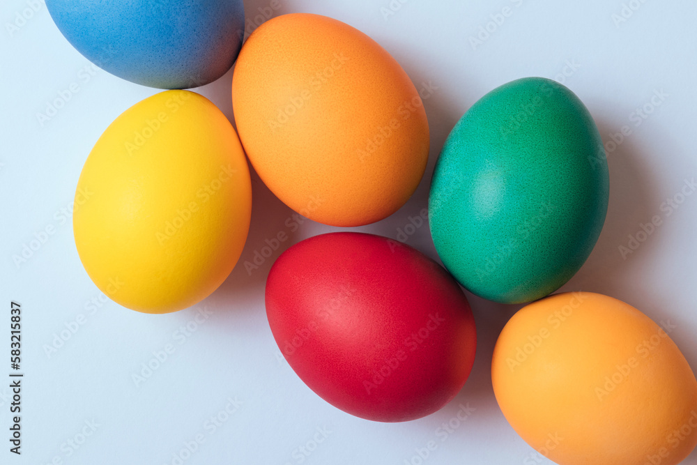 Colorful painted eggs on light background. Easter eggs. Top view. Macro shot, selective focus.