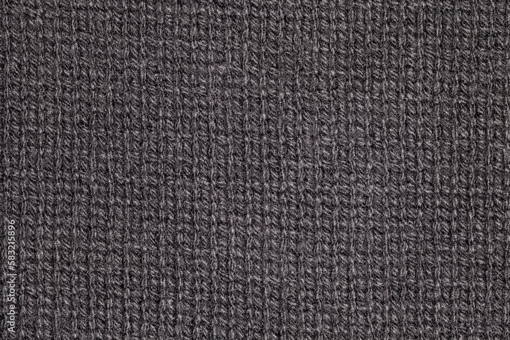 Fototapeta premium Fabric knitted with black spinning threads close-up knitting, background wallpaper, uniform texture pattern